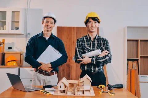 Asian architect and engineer team checking architectural house model using .. Stock Photos
