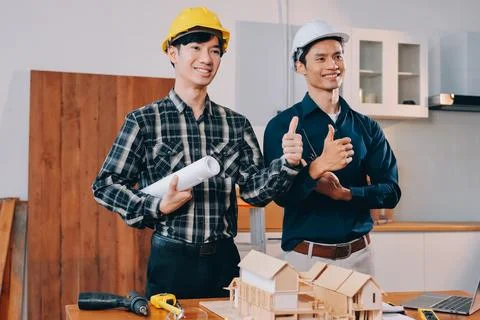 Asian architect and engineer team checking architectural house model using .. Stock Photos