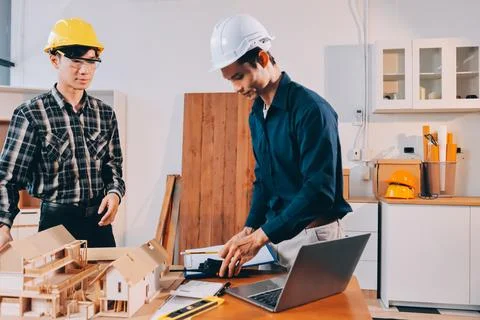 Asian architect and engineer team checking architectural house model using .. Stock Photos
