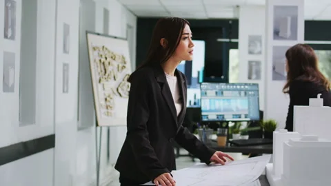 Asian architect studying blueprint papers in creative agency Video stock 262996073