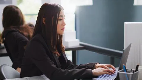 Asian architect translating floor plan measurements on laptop Stock Photos