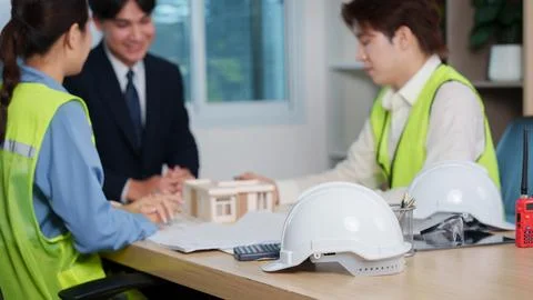 Asian architects and engineer discussing house building model in office meeting Stock Photos