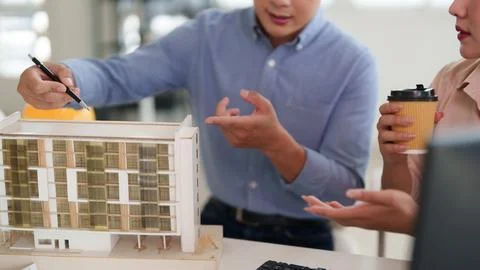 Asian architects collaborating on urban development project reviewing build.. Stock Photos