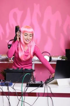 Asian artist having fun while performing eletronic music in night club Stock Photos