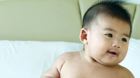 Asian Baby happy playing on the bad Stock Footage