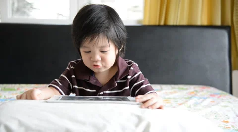 Asian baby using tablet on bed Stock Footage 49446785