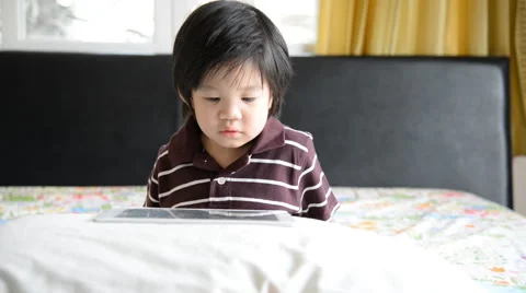 Asian baby using tablet on bed Stock Footage 49446815