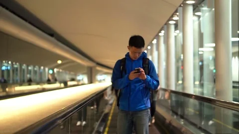 Asian backpacker man checking using smart phone at airport Stock Footage 76122524