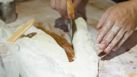 Asian Baker Using Bench Scraper to Cut Dough on Wooden Table Stock Footage 340884037