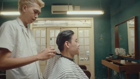 Asian Barber Putting a Cape on Client before Haircut Stock Footage 236815559