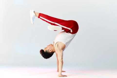 Asian Bboy standing in freeze stunt upside down balancing in air with legs Stock Photos
