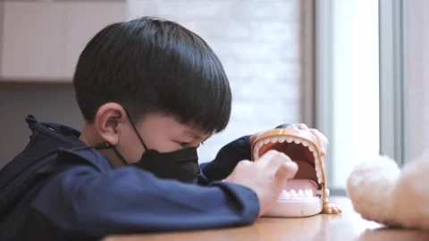 Asian boy about 7 years playing with finger biting toy. Video stock 276350302