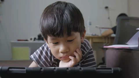 Asian boy addicted watching tablet while his mother working. Stock Footage 156603204