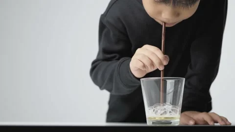 Asian boy blowing soap bubble with a plastic straw. Video stock 157058024
