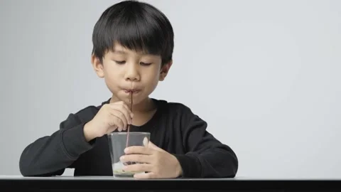 Asian boy blowing soap bubble with a plastic straw. Stock Footage 165682274