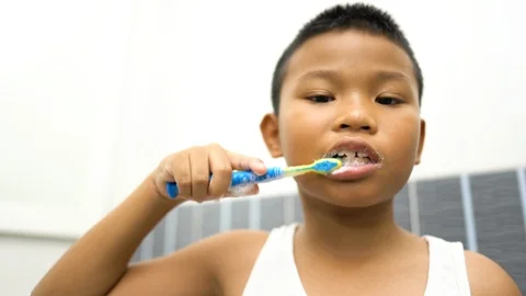 Asian boy brushing his teeth in bathroom. Stock Footage 113286421