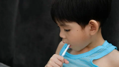Asian boy brushing his teeth on the living room Stock Footage 252079108