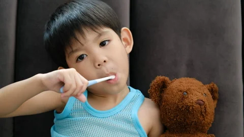 Asian boy brushing his teeth on the living room Stock Footage 252079220