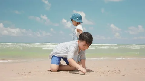 Asian boy child scribble in the sand at the beach on the summer day. Video stock 156876594