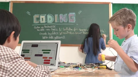 Asian boy coding program while friend fixing electric board at class. Pedagogy. Stock Footage 268682577