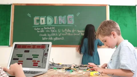 Asian boy coding program while friend fixing electric board at class. Pedagogy. Stock Footage 271375347