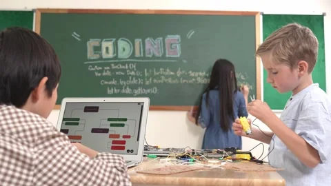 Asian boy coding program while friend fixing electric board at class. Pedagogy. Stock Footage 277355990