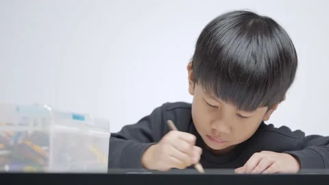 Asian boy doing his homework, drawing and painting picture. Video stock 156603232