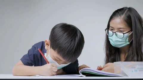 Asian boy doing homework with mother. Stock Footage 154347714