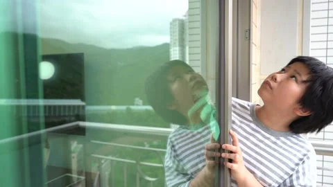 Asian boy doing housework to clean the glass door and window at home 4K Stock Footage 139567149