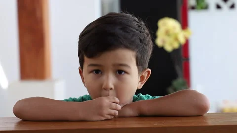 Asian boy eats cucumber on the kitchen. Healthy food concept. Stock Footage 159489274