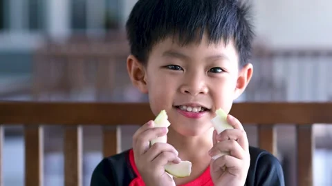 Asian boy eats guava fruit with happiness Stock Footage 277655876