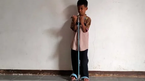 Asian Boy Exercising at Home Using Elastic Resistance Band Tummy Trimmer 库存影片 339657572