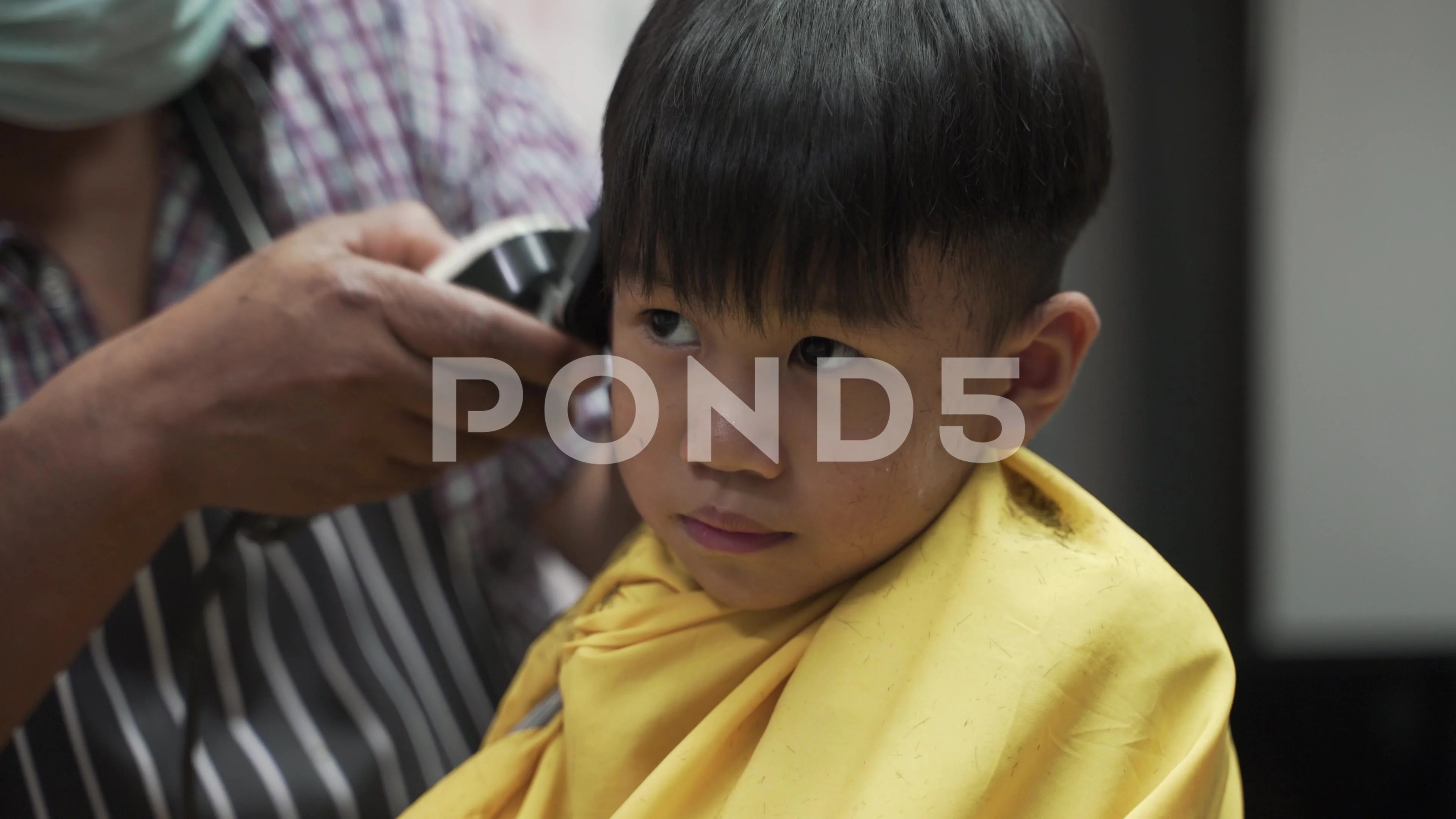 Asian boy getting haircut | Stock Video | Pond5