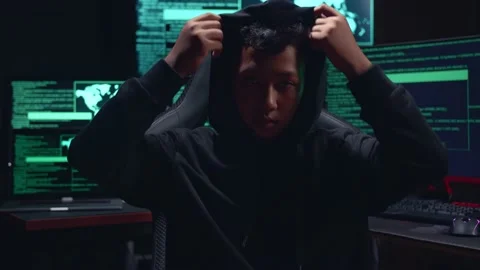 Asian Boy Hacker Takes Off His Hood And Pose With Multiple Computer Screens Stock-Footage 157329129