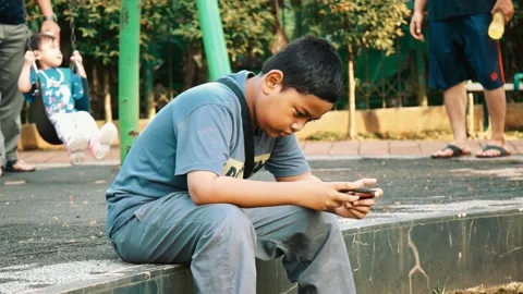 An asian boy is happy when he wins in a mobile game Stock Footage 214776795