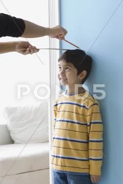 Asian boy having height measured on wall Stock Photos