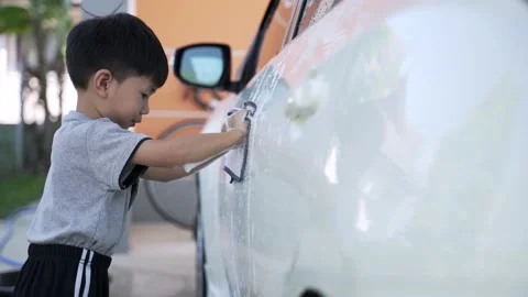 Asian boy helping house work as washing car by himself, learning concept Video stock 147337432