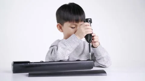 Asian boy holding screwdriver for fixing the electronic speaker Video stock 147337276