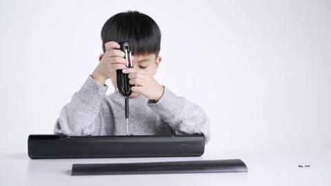 Asian boy holding screwdriver for fixing the electronic speaker Stock Footage 160277625