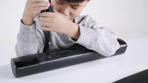 Asian boy holding screwdriver for fixing the electronic speaker Video stock 163286780
