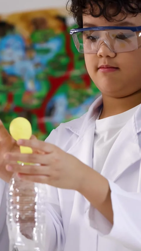 Asian Boy in Lab Coat Performing Science Experiment with Balloon and Bottle Video stock 338154955