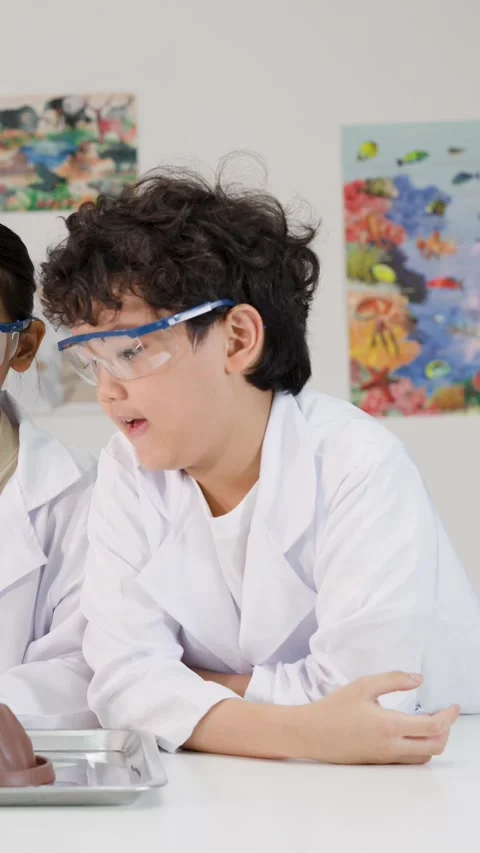 Asian Boy in Lab Coat Reacting to Science Experiment in Classroom Stock Footage 340243091