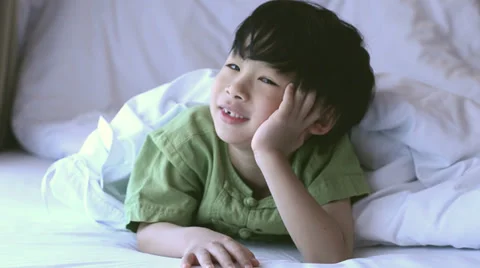 Asian boy laughing on bed Stock Footage 37131089