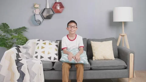 Asian boy laughs looking at camera in living room at home. Stock-Footage 155158098