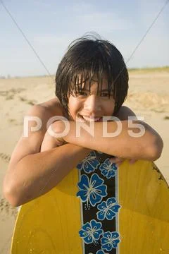 Asian boy leaning on surfboard Stock Photos