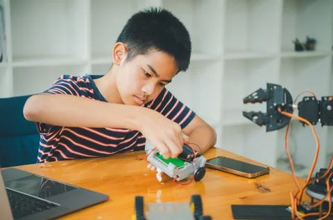 Asian boy learning and studying the work of technology robots.homeschool an.. Stock Photos