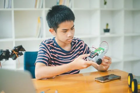 Asian boy learning and studying the work of technology robots.homeschool an.. Stock Photos