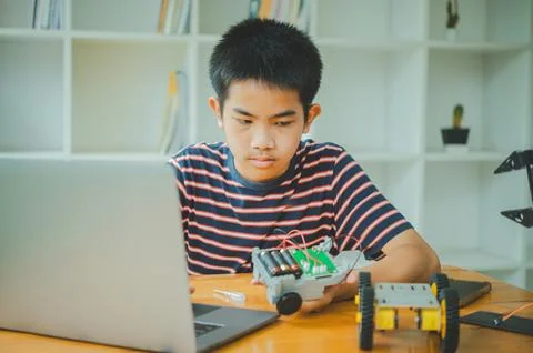 Asian boy learning and studying the work of technology robots.homeschool an.. Stock Photos