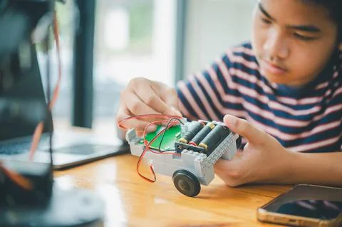 Asian boy learning and studying the work of technology robots.homeschool an.. Stock Photos