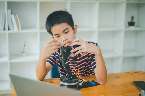 Asian boy learning and studying the work of technology robots.homeschool an.. Stock Photos